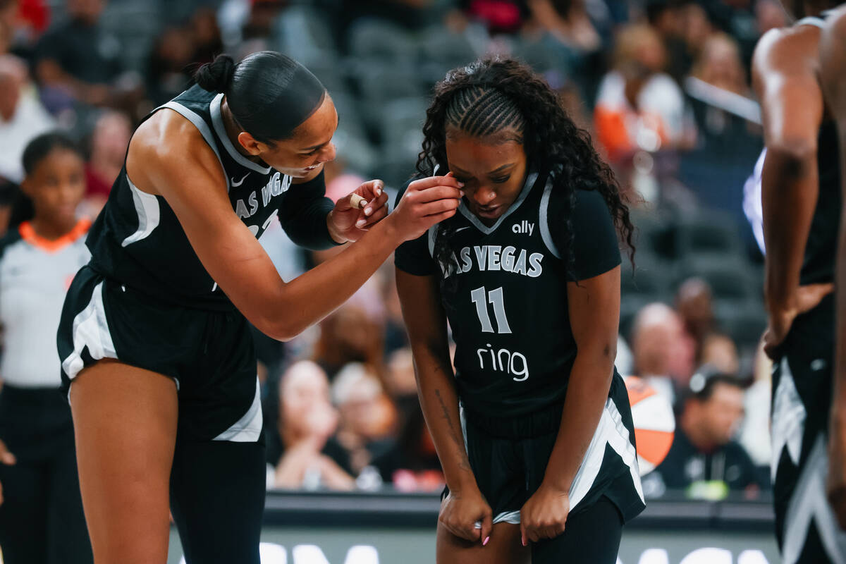 Aces center A'ja Wilson (22) helps Aces guard Dana Evans (11) adjust an eyelash during the ...