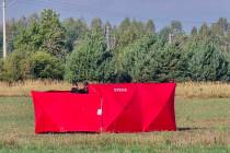 Firefighters secure parts of a damaged UAV shot down by Polish authorities at a site in Czosnow ...