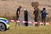 In this image made from video, Police and Military Police secure parts of a damaged object shot ...