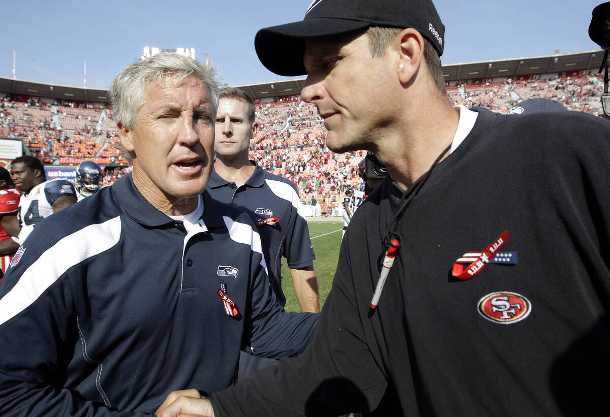 Seattle Seahawks coach Pete Carroll, left, shakes hands with San Francisco 49ers coach Jim Harb ...