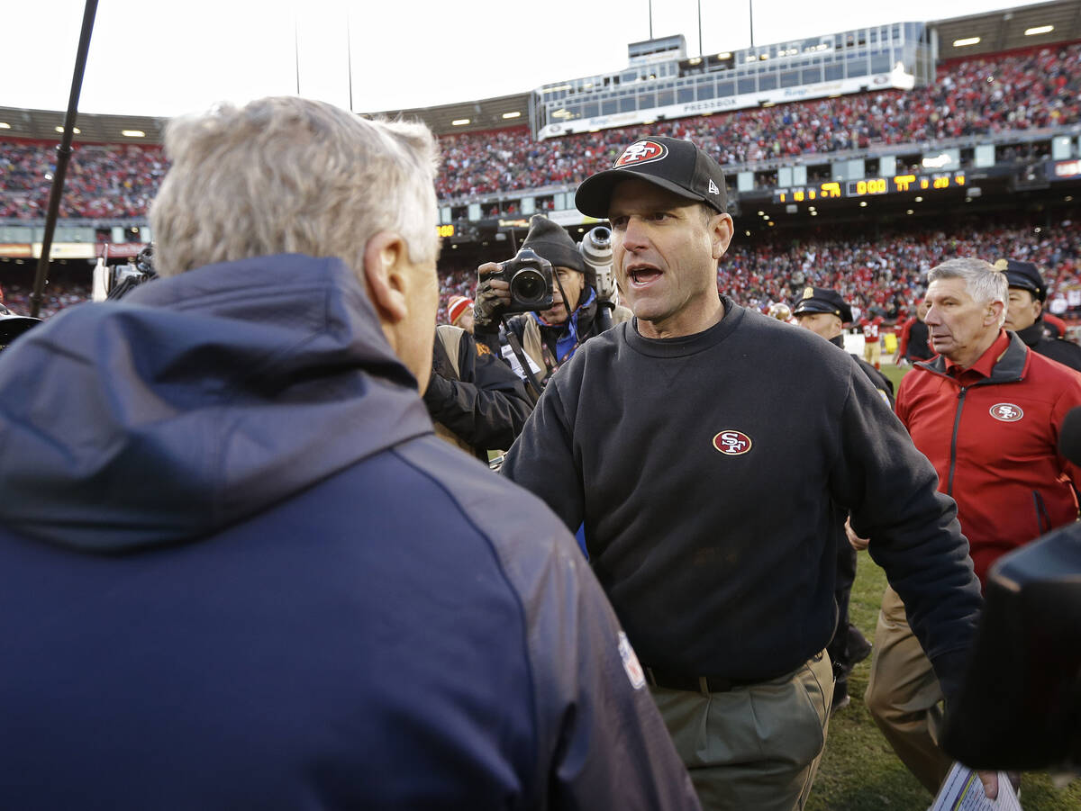 San Francisco 49ers head coach Jim Harbaugh, right, shakes hands with Seattle Seahawks head coa ...