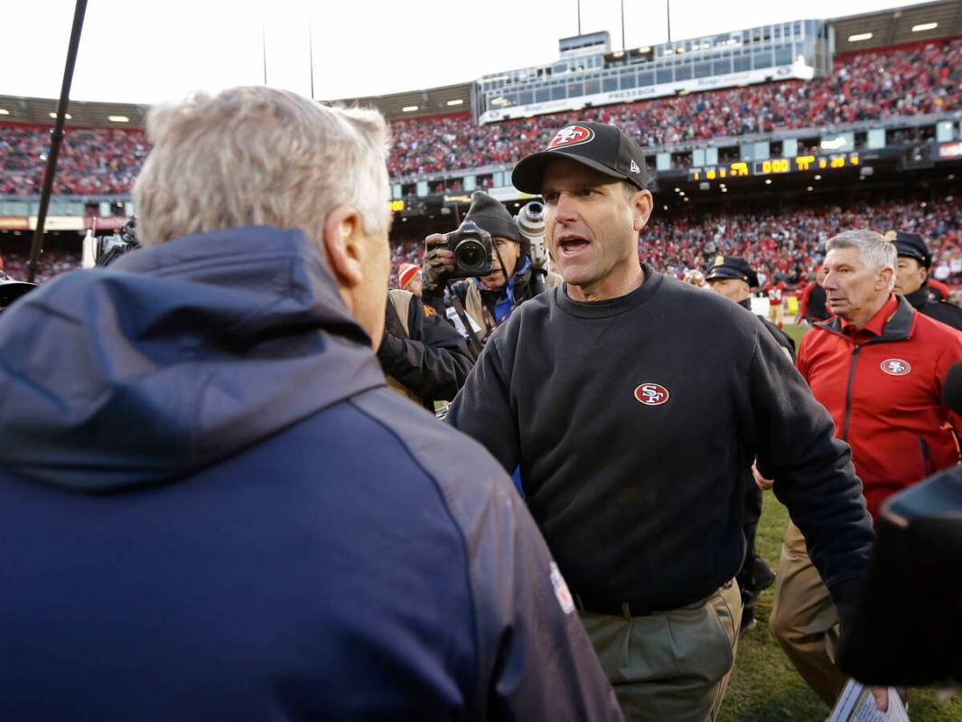 San Francisco 49ers head coach Jim Harbaugh, right, shakes hands with Seattle Seahawks head coa ...