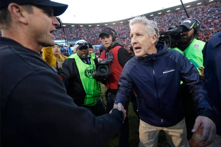FILE - In this Dec. 8, 2013, file photo, San Francisco 49ers head coach Jim Harbaugh, left, sha ...
