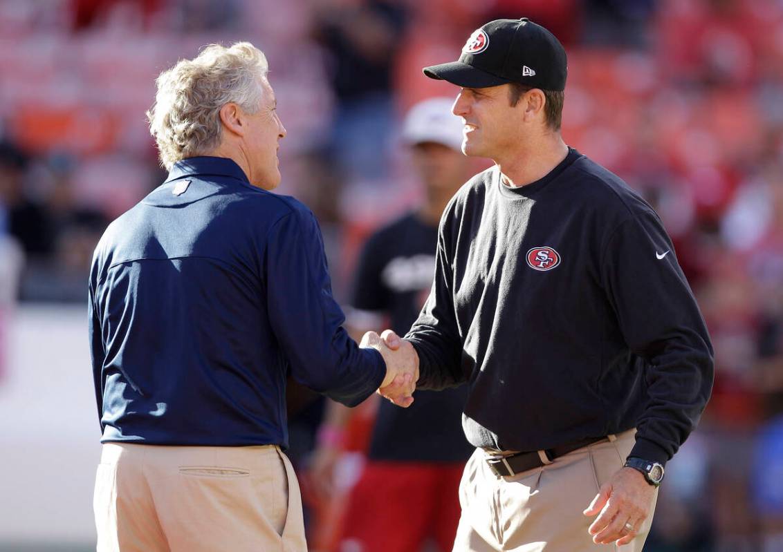 Seattle Seahawks head coach Pete Carroll, left, shakes hands with San Francisco 49ers head coac ...