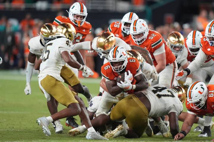 Miami running back CharMar Brown (6) is tackled during the second half of an NCAA college footb ...