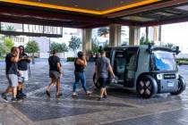 Passengers walk to their Zoox vehicle leaving from Resorts World on Friday, Sept. 05, 2025, in ...
