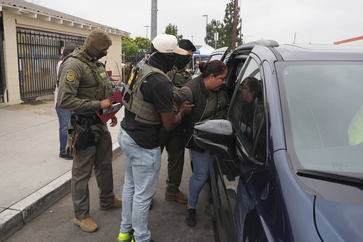 A woman is detained by U.S. Border Patrol agents outside a Home Depot Friday, Aug. 15, 2025, in ...