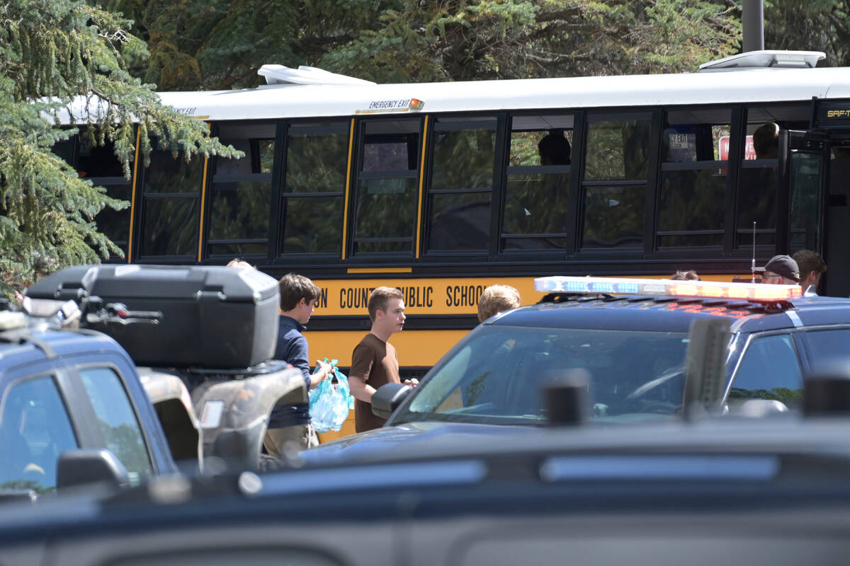 Students board a bus amid heavy police presence at the Evergreen Library after a shooting at Ev ...