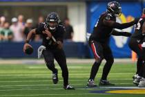Houston Texans quarterback C.J. Stroud, left, scrambles against the Los Angeles Rams during the ...
