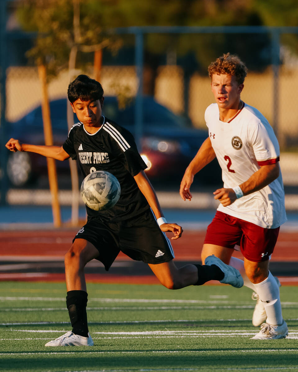 Desert Pines midfielder Brian Sosa (8) takes control of the ball with Faith Lutheran defender N ...