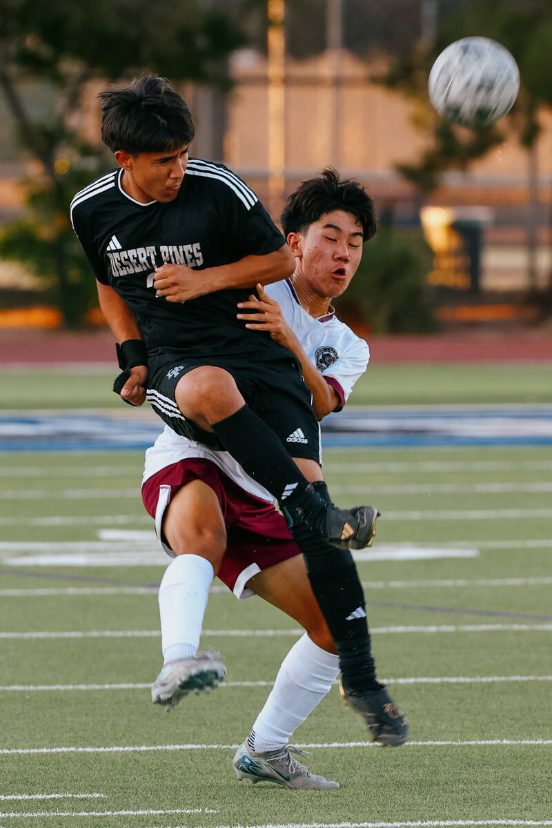 Desert Pines striker Cesar Sanchez (25) and Faith Lutheran midfielder Paul Slaninka (11) wrestl ...