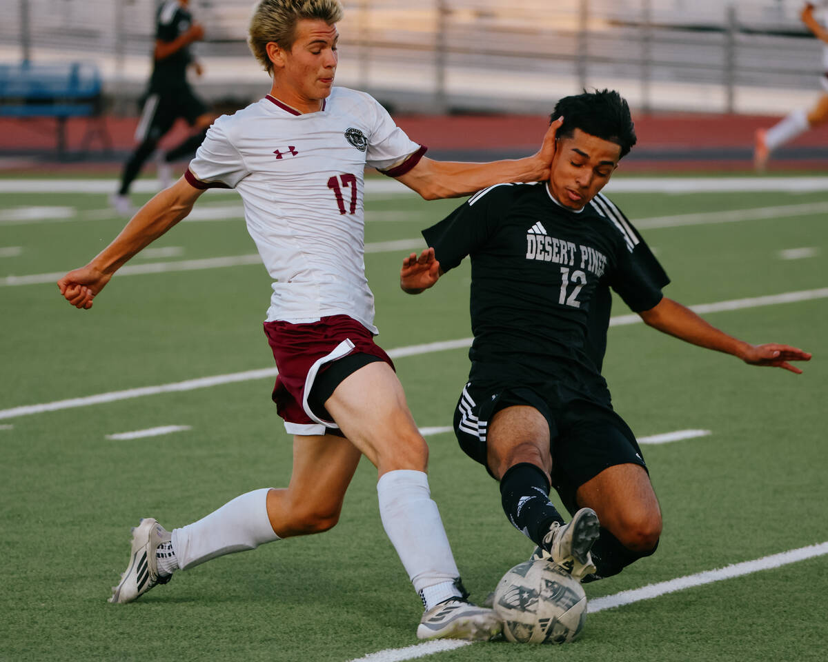 Faith Lutheran forward Tohotom Hajdu (17) and Desert Pines fullback Dorian Hernandez (12) spar ...