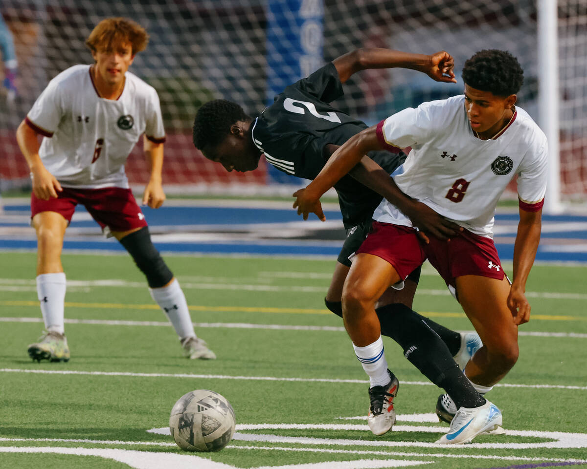 Desert Pines fullback Gardson Destine (2) and Faith Lutheran defender Isaiah Hopes (8) spar for ...