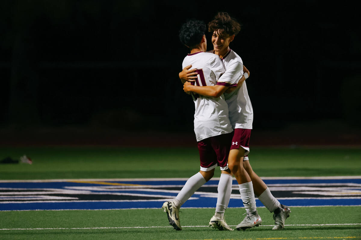 Faith Lutheran’s Jayden Serrano (20) and Paul Slaninka (11) embrace, celebrating a goal ...