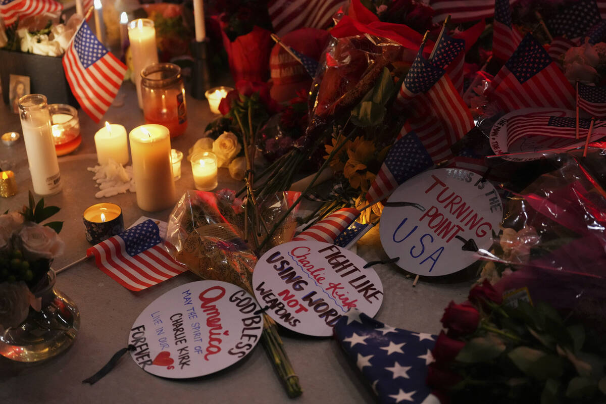 Flags, candles and signs sit at a vigil for Charlie Kirk, the CEO and co-founder of Turning Poi ...