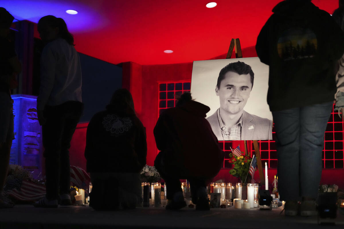 People place lit candles below a photo of Charlie Kirk, the CEO and co-founder of Turning Point ...