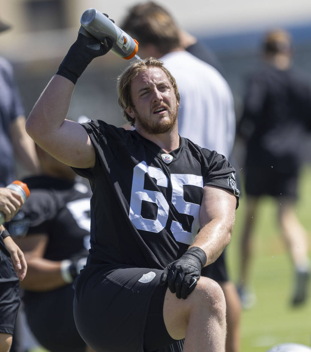 Raiders offensive lineman Alex Cappa (65) sprays his head with water during the team’s p ...
