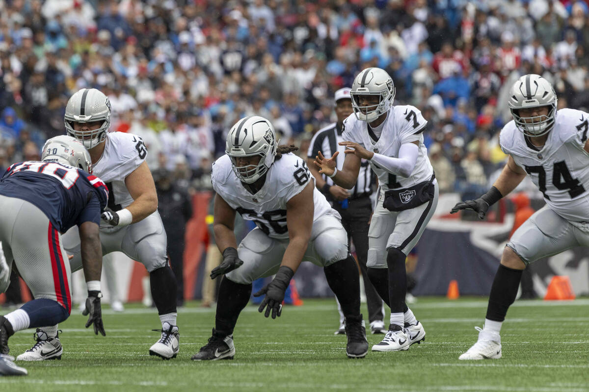Raiders quarterback Geno Smith (7) prepares to grab the snap from Raiders guard Jordan Meredith ...