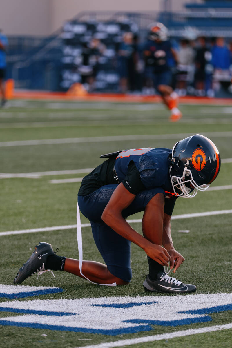 Bishop Gorman defensive back Brayley Manning (24) ties his cleat while warming up before the fo ...