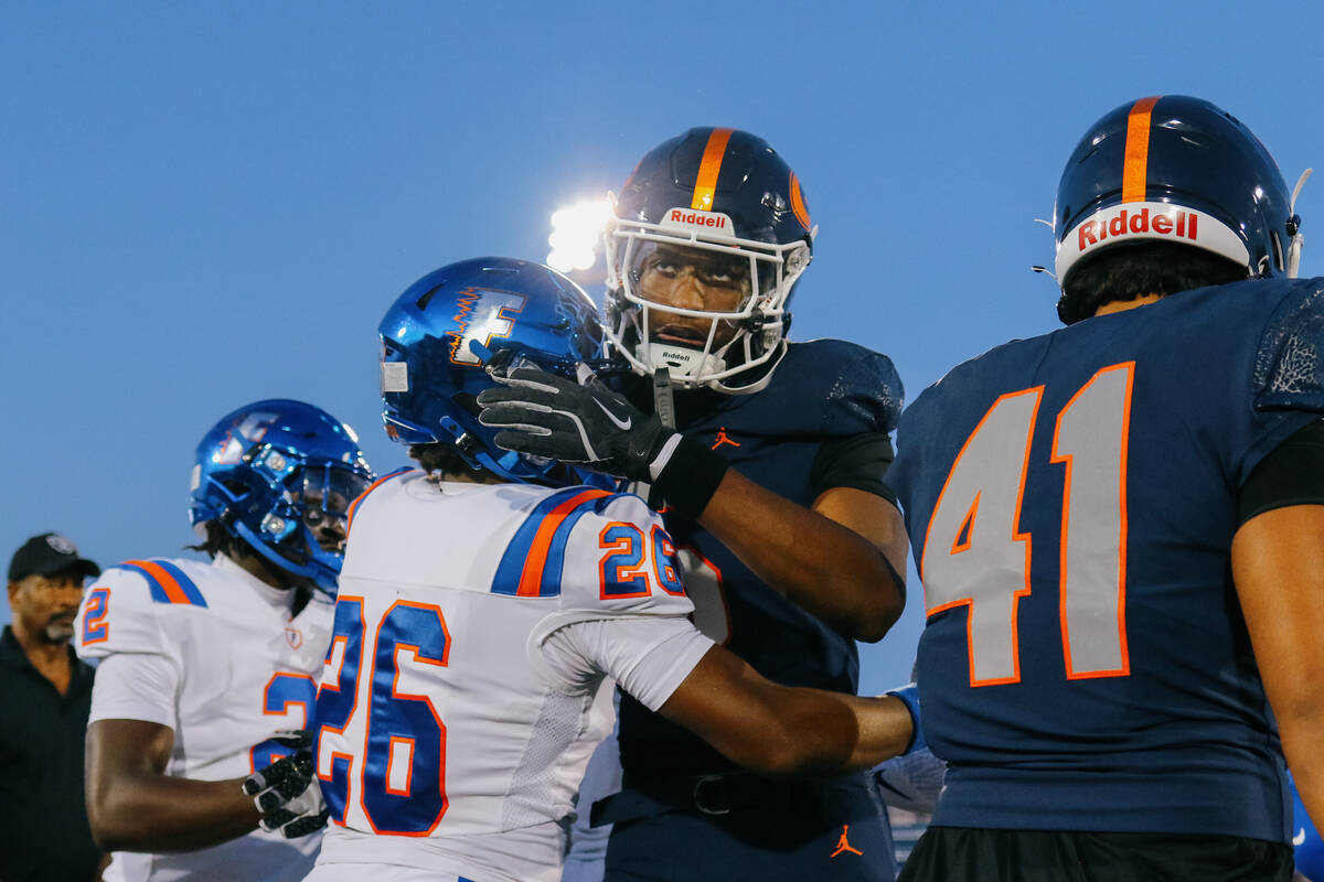 Bishop Gorman defensive back/wide receiver Jett Washington (5) hugs East St. Louis running back ...