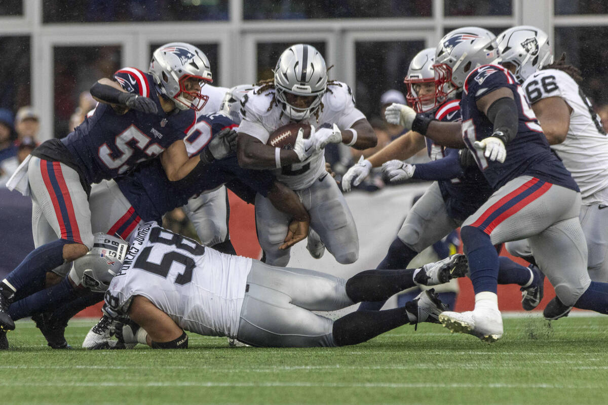 Patriots defenders close in on Raiders running back Ashton Jeanty (2) as Raiders center Jackson ...