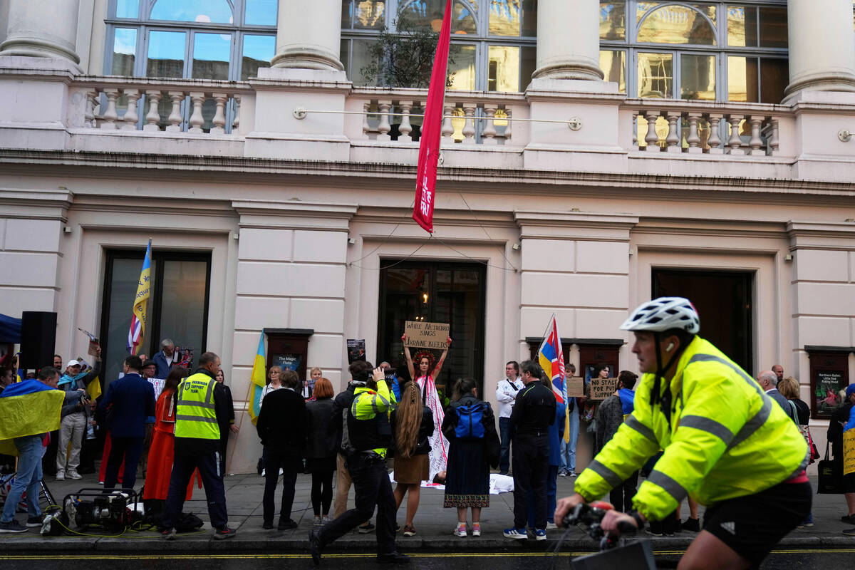 Pro-Ukraine protesters hold up placards and flags during a demonstration against the Royal Oper ...