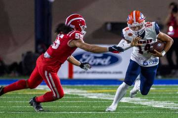 Bishop Gorman quarterback Maika Eugenio (14) looks to evade a tackle attempt by Mater Dei lineb ...