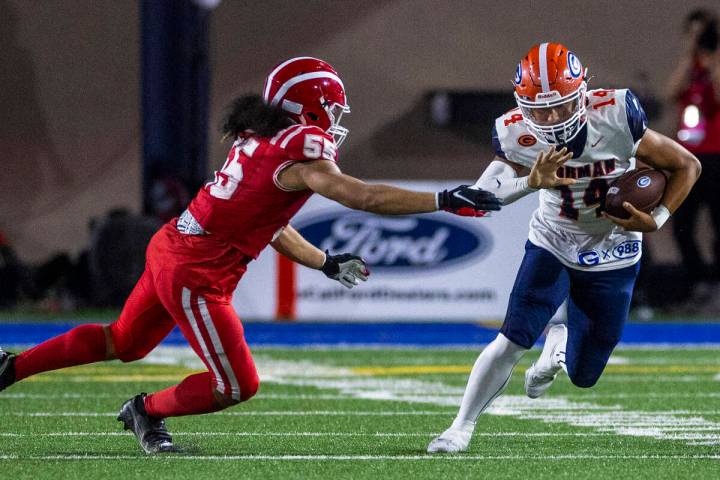 Bishop Gorman quarterback Maika Eugenio (14) looks to evade a tackle attempt by Mater Dei lineb ...