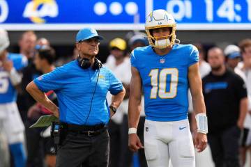 Los Angeles Chargers head coach Jim Harbaugh, left, and quarterback Justin Herbert (10) watch a ...