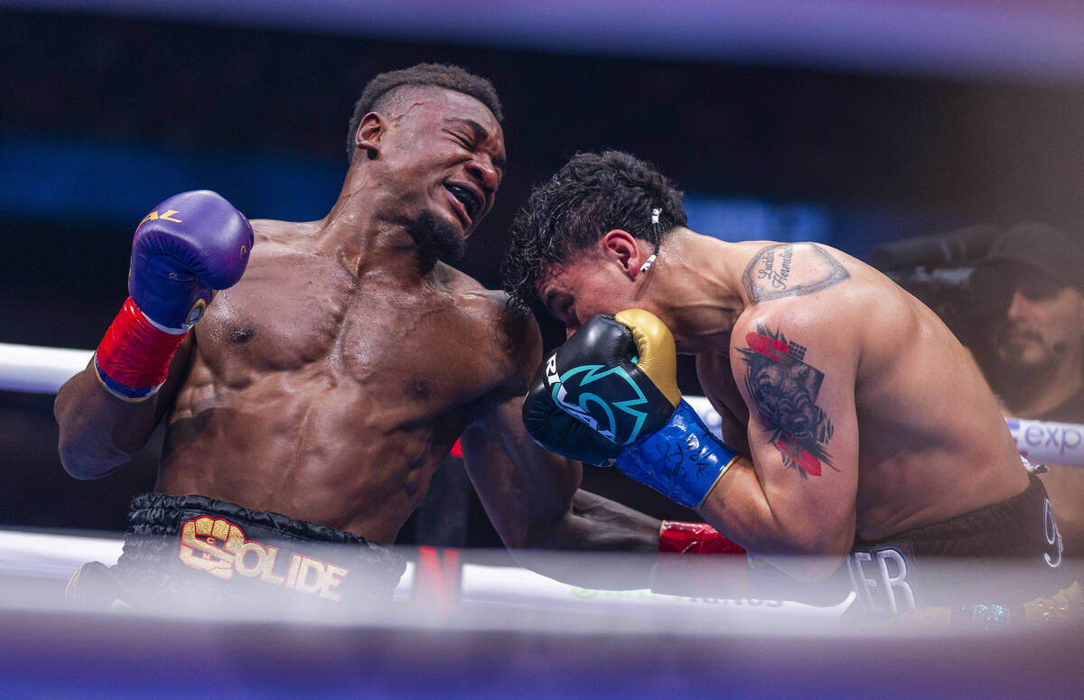 Christian Mbilli drives a punch to the stomach of Lester Martinez during their super middleweig ...