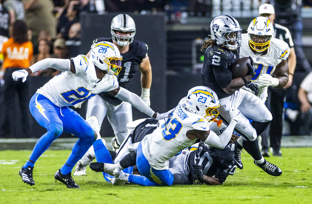 Raiders running back Ashton Jeanty (2) looks to break a tackle by Los Angeles Chargers safety T ...