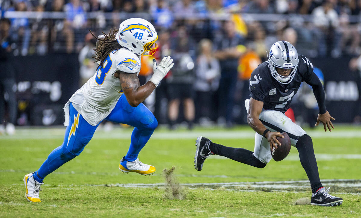 Raiders quarterback Geno Smith (7) evades a sack from Los Angeles Chargers linebacker Bud Dupre ...