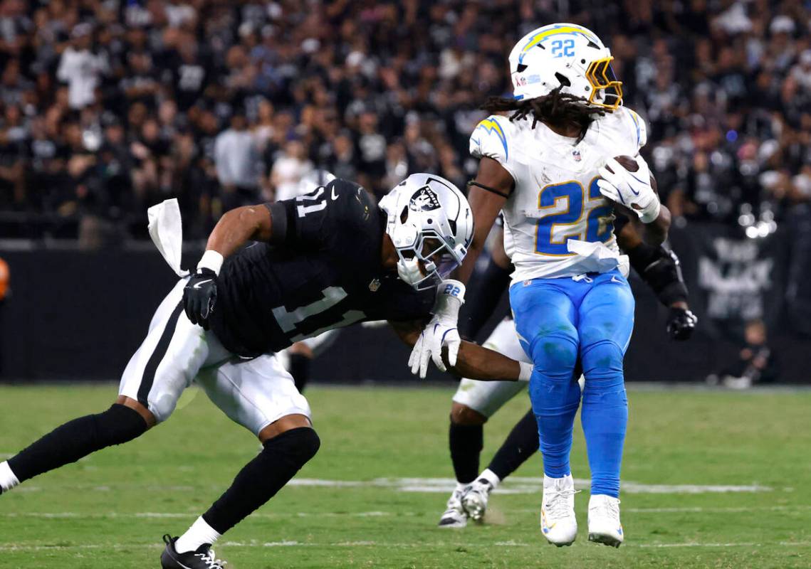 Los Angeles Chargers running back Najee Harris (22) avoids a tackle from Raiders safety Jeremy ...