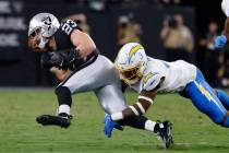 Raiders running back Dylan Laube (23) is taken down by Los Angeles Chargers safety Derwin James ...