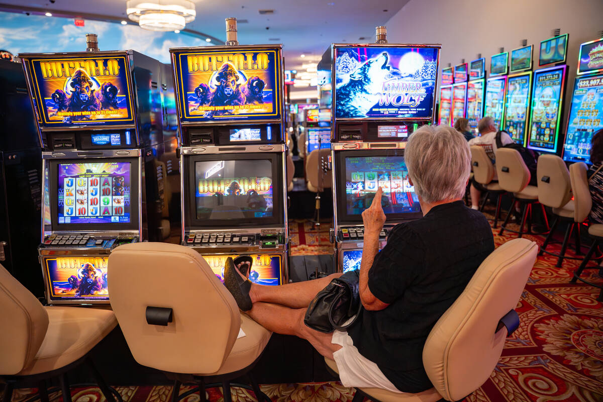 A guest smokes while playing a slot machine at the CasaBlanca Resort and Casino in Mesquite, Ne ...