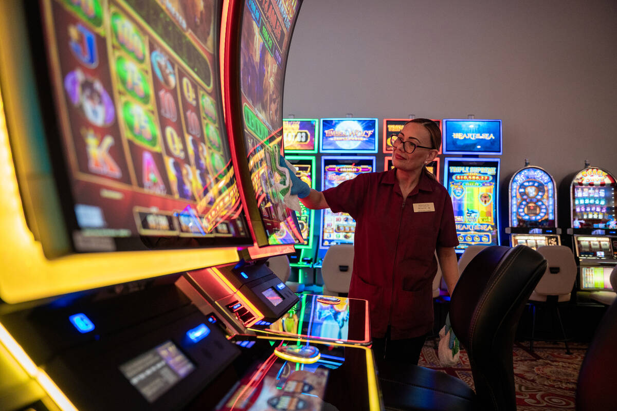 Marqueza, who declined to give her surname wipes down a slot machine after a patron leaves at t ...