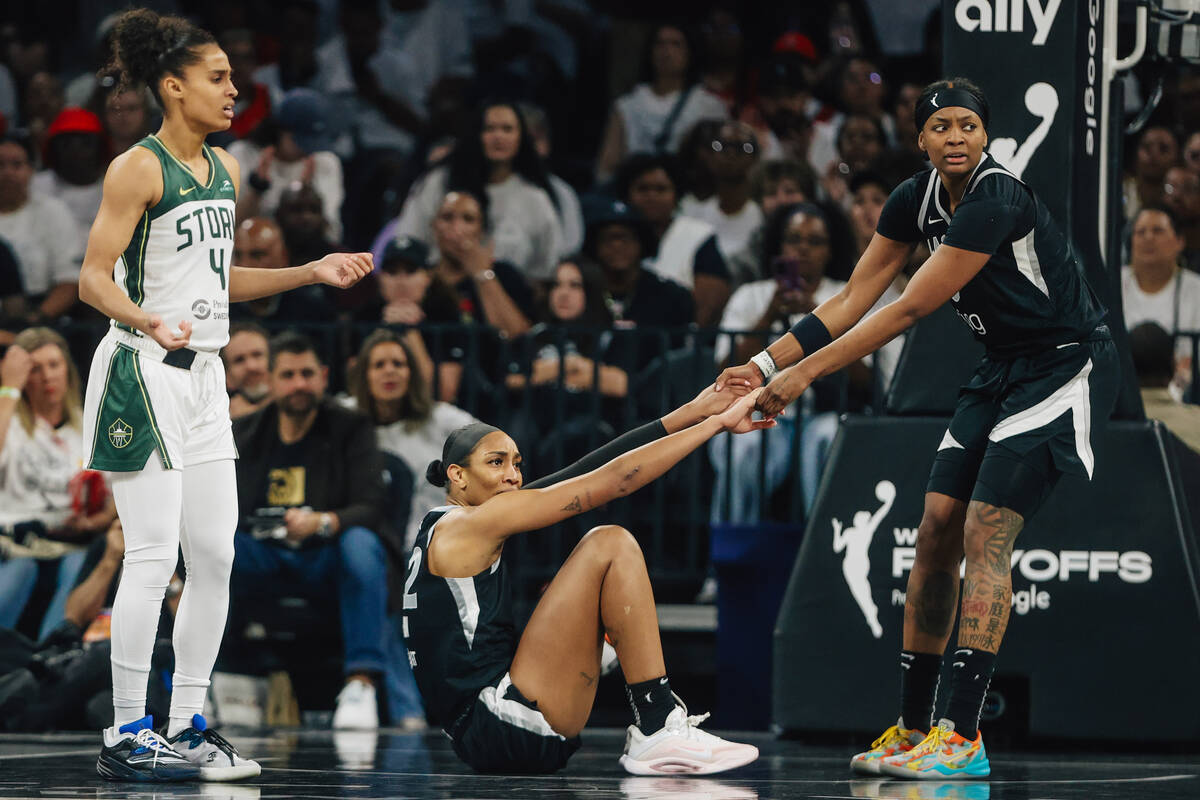 Aces forward NaLyssa Smith (3) helps up Aces center A'ja Wilson (22) during game one of a ...