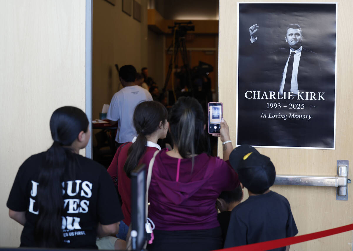 Attendees take photos before the start of a vigil for Charlie Kirk hosted by Turning Point at t ...