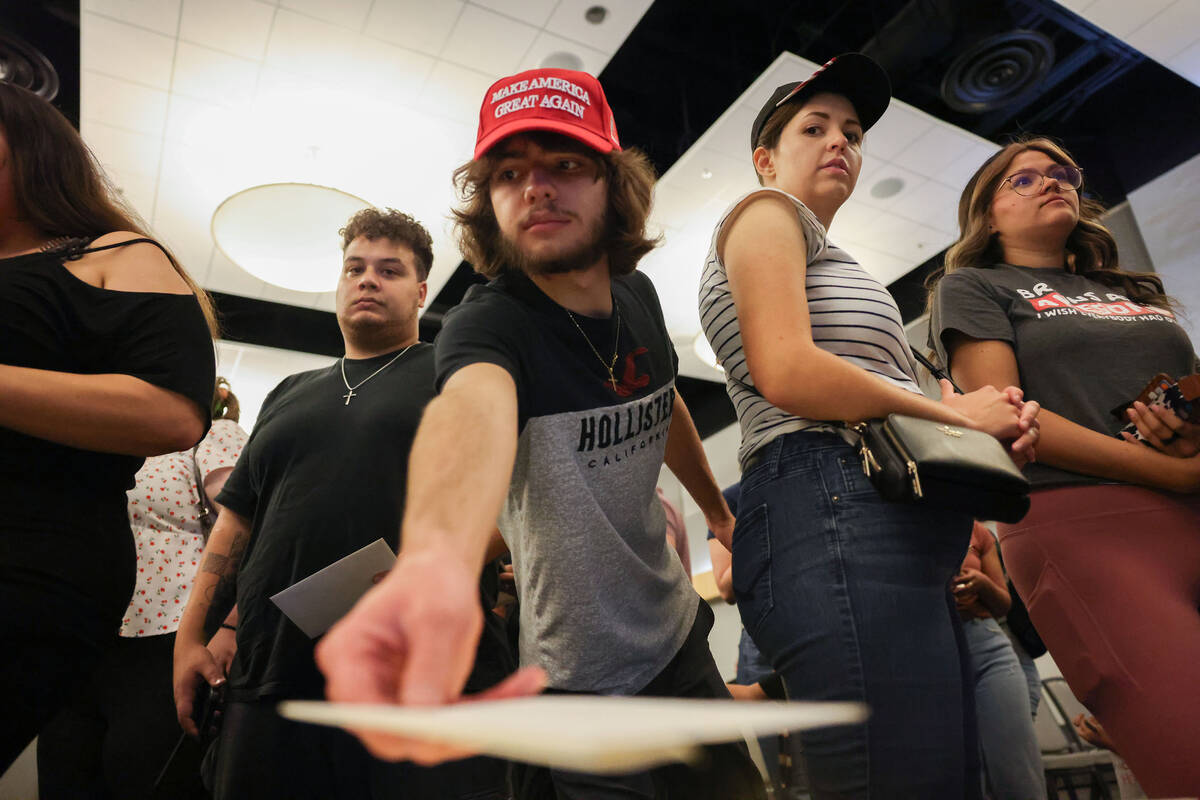 Attendees drop letters of condolence during a vigil for Charlie Kirk hosted by Turning Point at ...