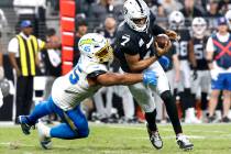 Raiders quarterback Geno Smith (7) breaks the tackle attempt by Los Angeles Chargers linebacker ...