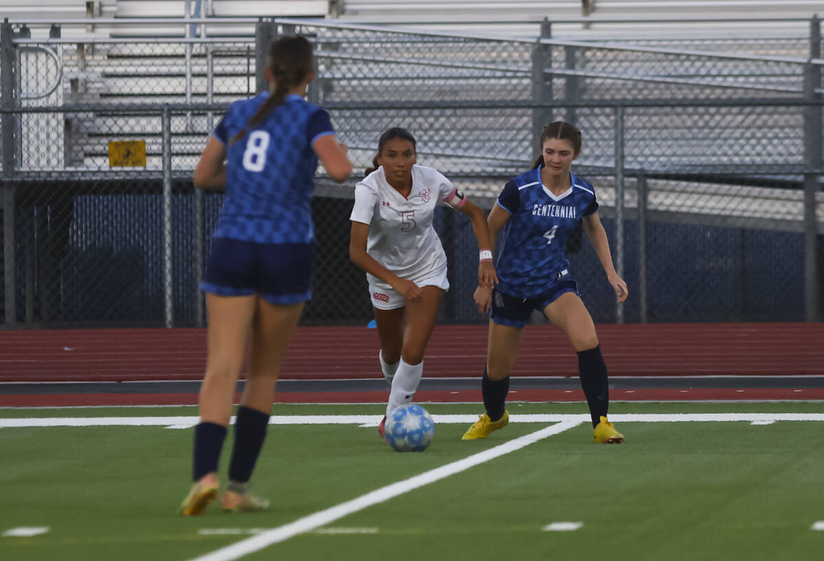 Arbor View's Jazlyn Chavez (5) moves the ball past Centennial's Rachel Foreman (4) du ...