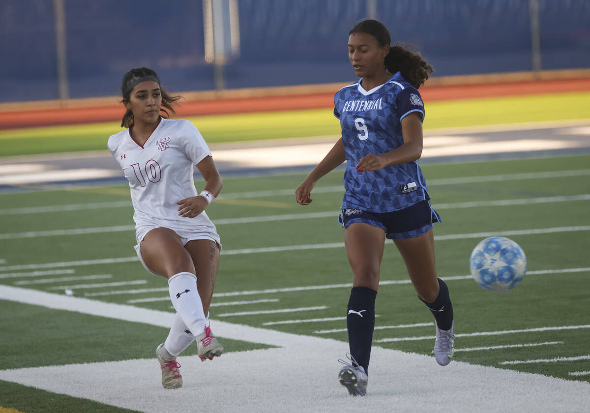 Arbor View's Natalie Limon (10) kicks the ball past Centennial's Alyce Cartwright (9) ...
