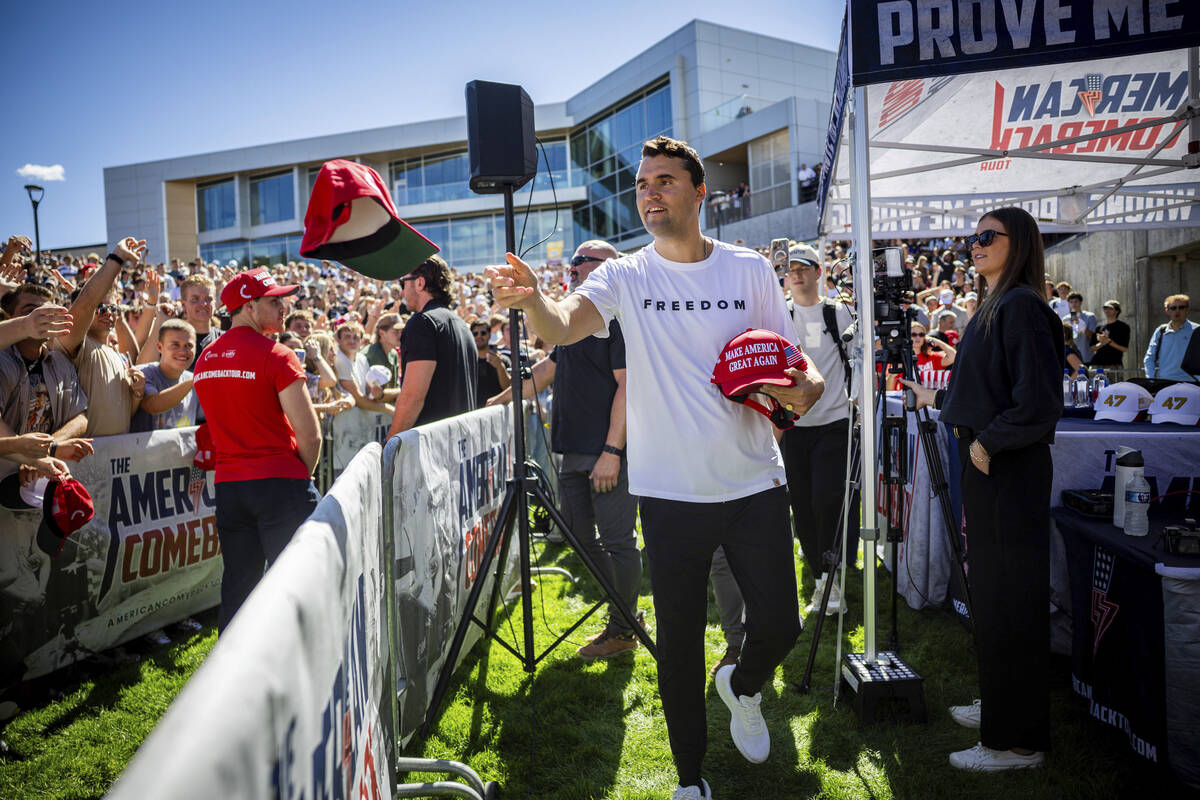 Charlie Kirk hands out hats before speaking at Utah Valley University in Orem, Utah, Wednesday, ...
