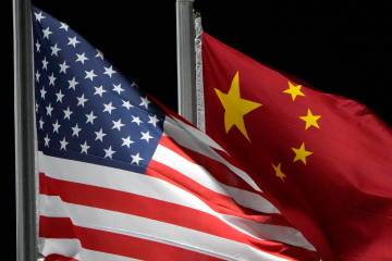 The American and Chinese flags wave, Feb. 2, 2022, in Zhangjiakou, China. (AP Photo/Kiichiro Sa ...