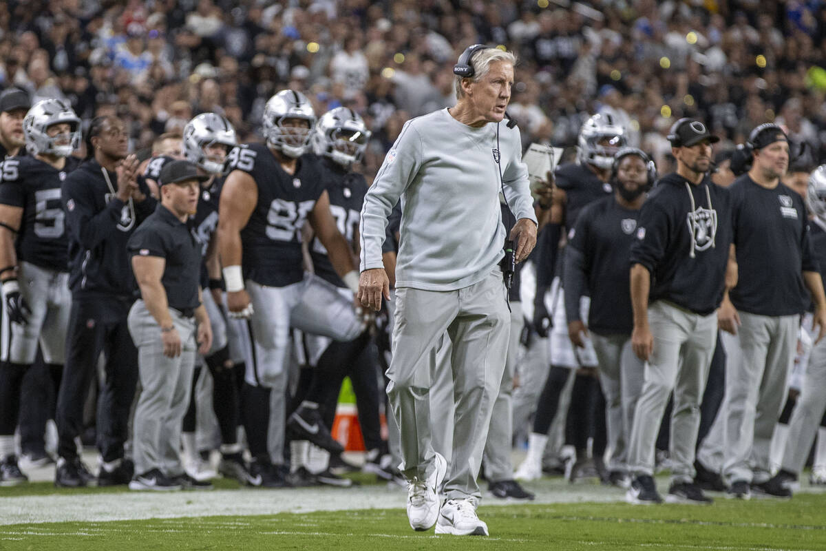 Raiders head coach Pete Carroll walks on the field during the first half of an NFL game against ...