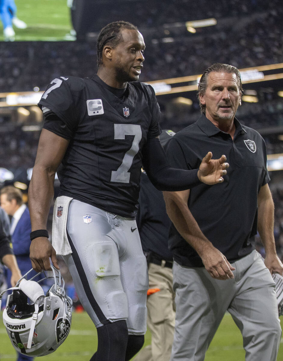 Raiders quarterback Geno Smith (7) speaks with quarterbacks coach Greg Olson as they walk off t ...