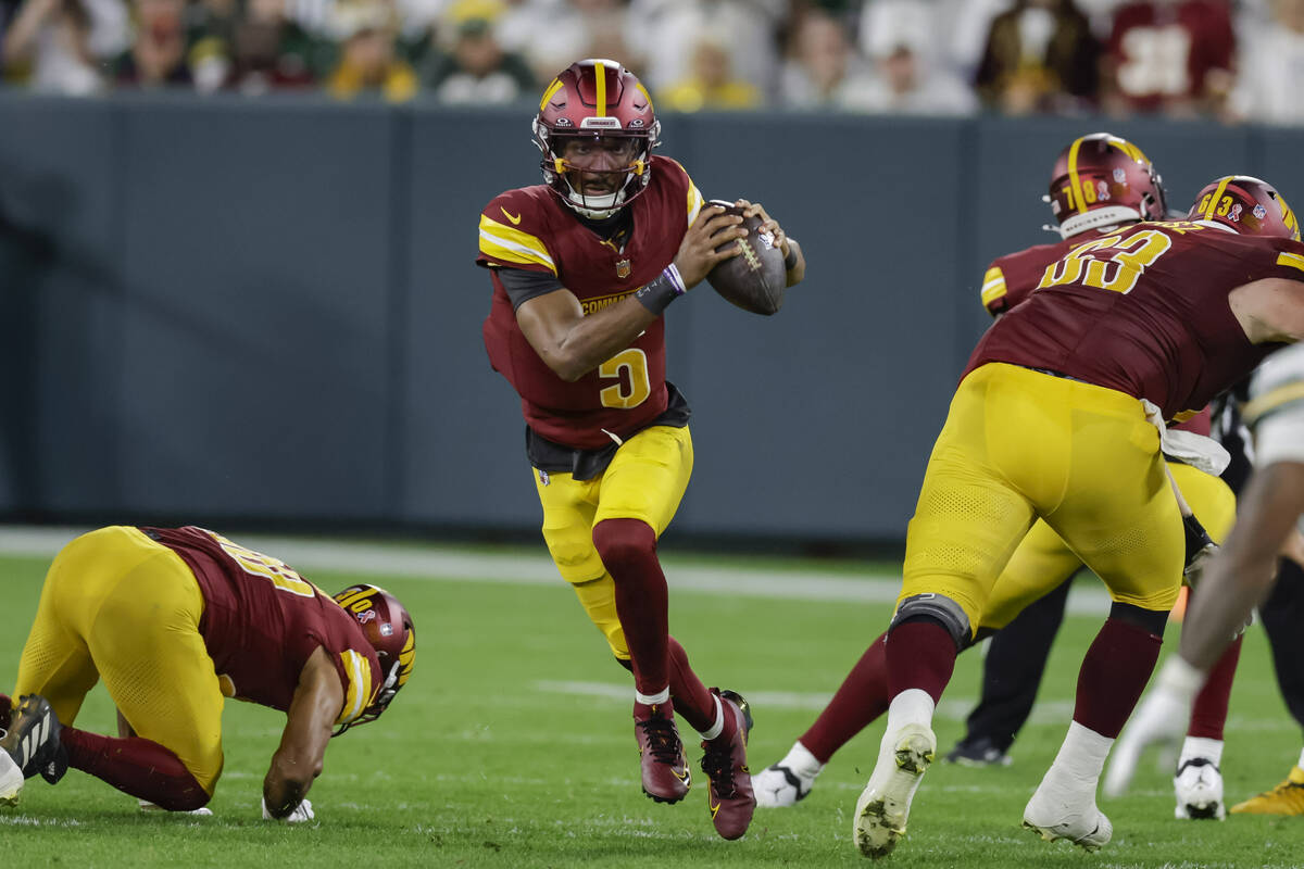 Washington Commanders quarterback Jayden Daniels (5) looks to pass during an NFL football game ...