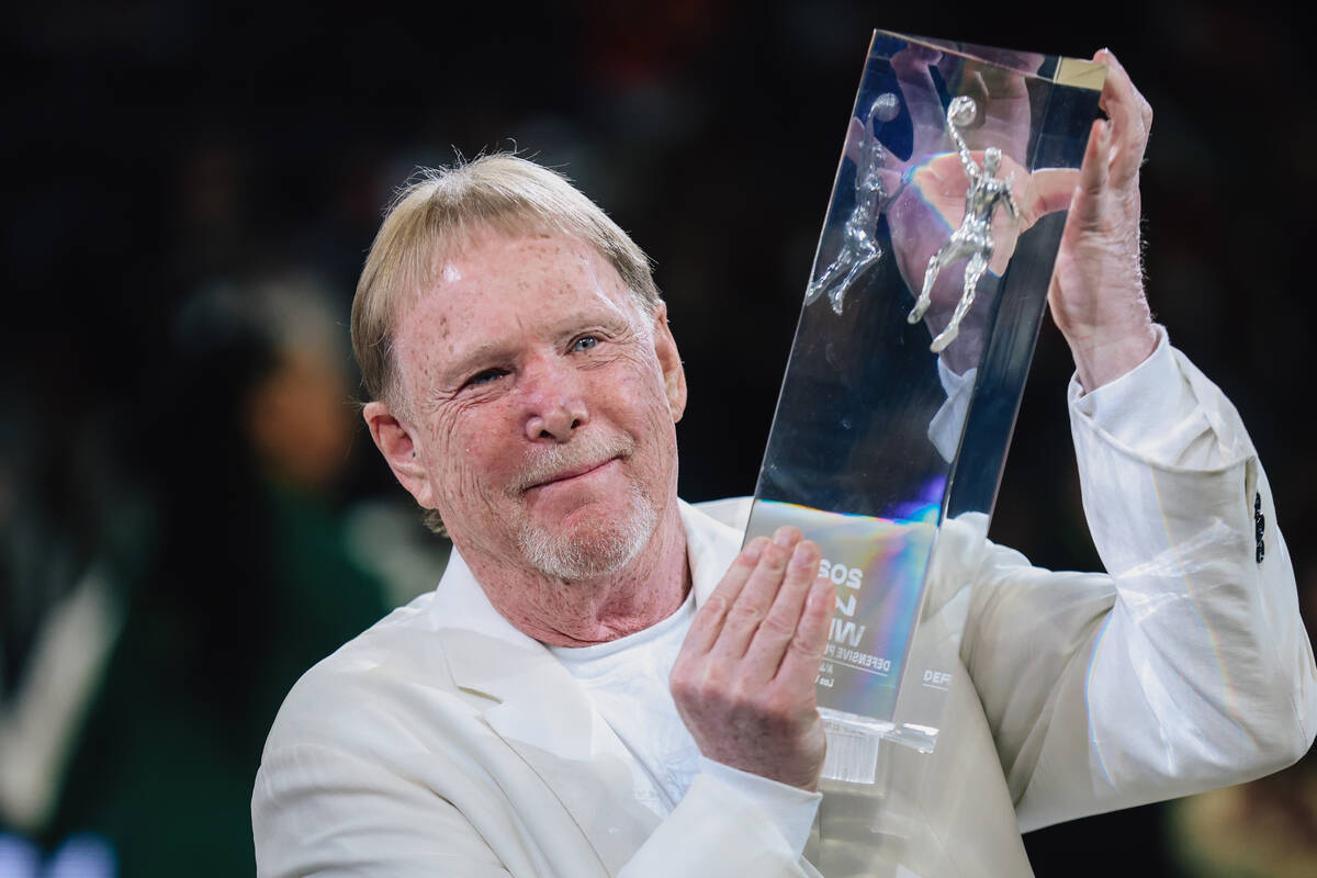 Mark Davis, owner of the Aces, holds up A’ja Wilson’s Defensive Player of the Yea ...