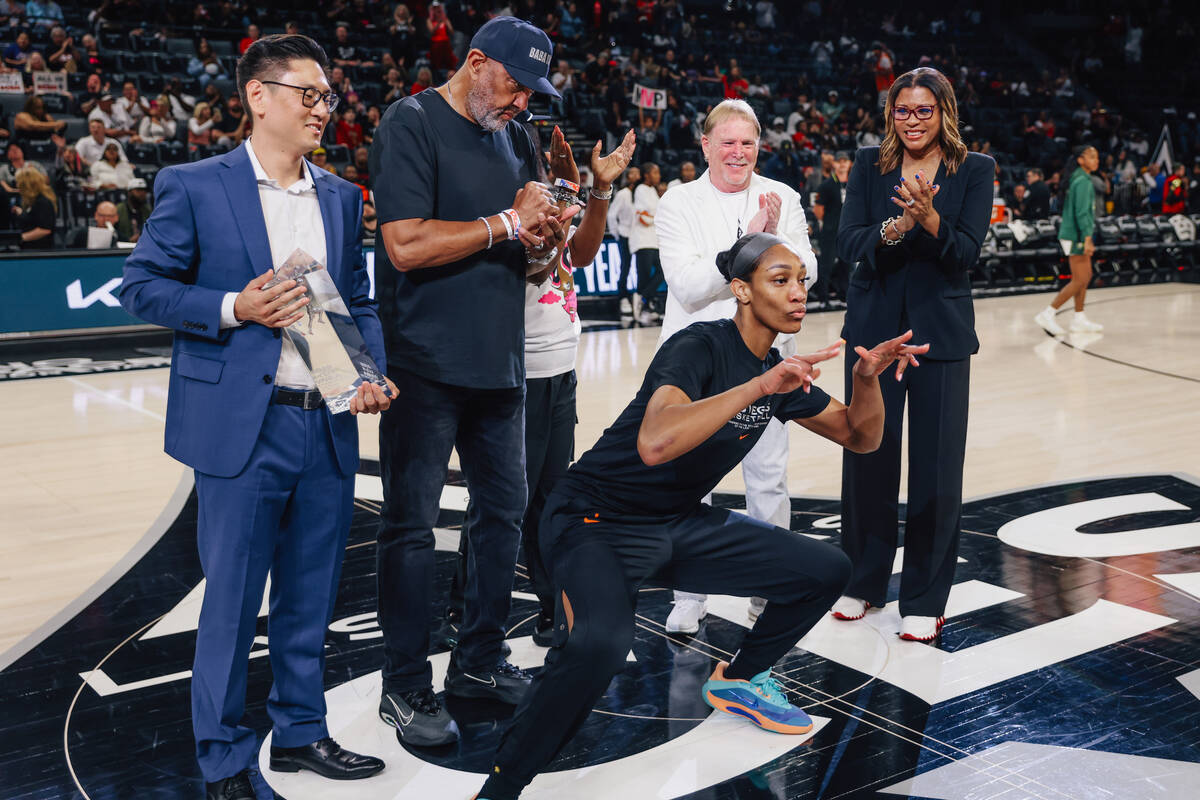 A’ja Wilson photobombs her Defensive Player of the Year trophy presentation during game ...