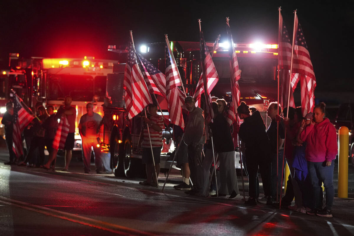 People hold American flags before a procession Wednesday, Sept. 17, 2025, in Spring Grove, Pa., ...
